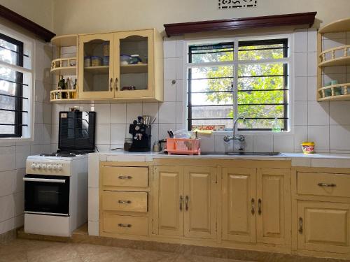 a kitchen with wooden cabinets and a white stove top oven at Casa Mianzini in Arusha