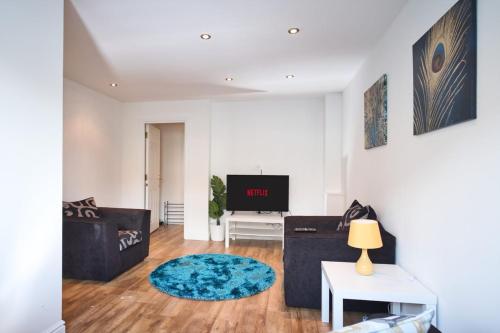 a living room with a couch and a tv at St Kats Mews 4 bed with parking in Peterborough