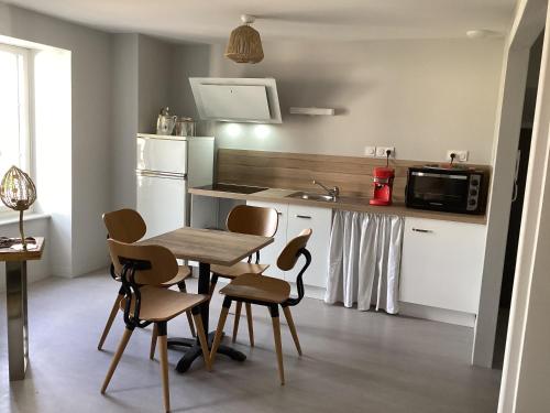 une cuisine avec une table et des chaises et un micro-ondes dans l'établissement La fontaine, à Cohade