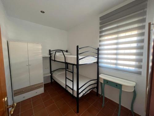 a small room with two bunk beds and a window at Seaside Paradise Mazagon in Mazagón