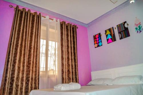 a bedroom with pink and purple walls and a bed at Zuri homes in Mombasa