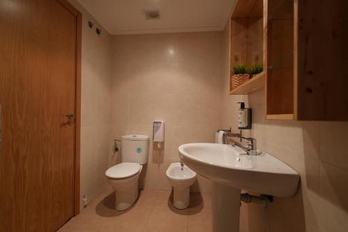 a bathroom with a toilet and a sink at Spirit Apartamentos Atxuri in Bilbao