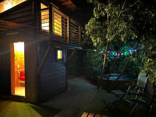 a small tree house with a patio at night at Les lucioles cabane chalet avec Jacuzzi privatif in Privas