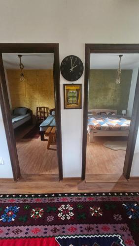 a room with a clock on the wall and a living room at Zlatiborsko Srce 2 in Zlatibor