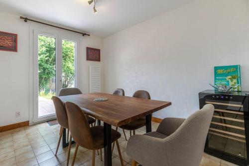 a dining room with a wooden table and chairs at L'Ozormo - Climatisée - Maison - Jardin in Amboise