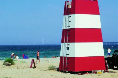 a red and white lighthouse on the beach at The Grand Nyborg Stay in Nyborg