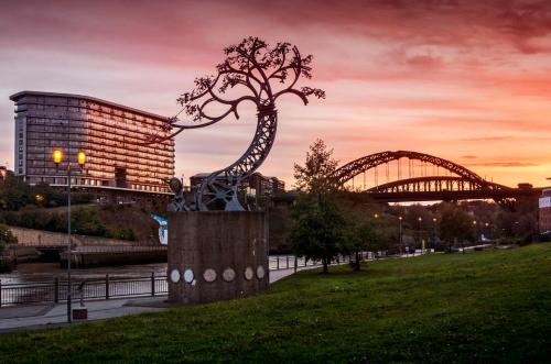 a statue of a tree with a bridge in the background at A&A Luxury Stay Rosedale St - Chic, Modern, City Centre, Neon Decor in Sunderland