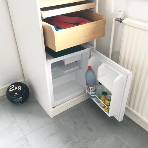 - un petit réfrigérateur blanc avec une porte ouverte dans l'établissement Bed and Breakfast Nantes au calme proche aéroport, gare et centre-ville, à Saint-Sébastien-sur-Loire