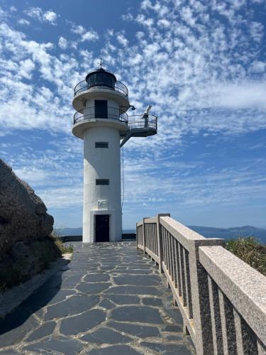 a lighthouse with a walkway leading up to it at Casal de pelaio in Barreiros