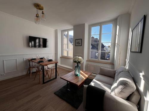 a living room with a couch and a table at Appartement Richard Merrill 2 personnes en plein centre in Sainte-Mère-Église