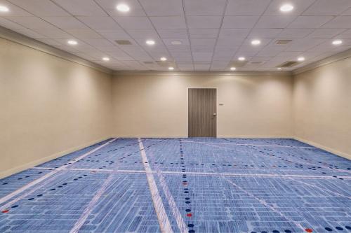 an empty swimming pool in a room with blue mats at Los Angeles Airport Marriott in Los Angeles