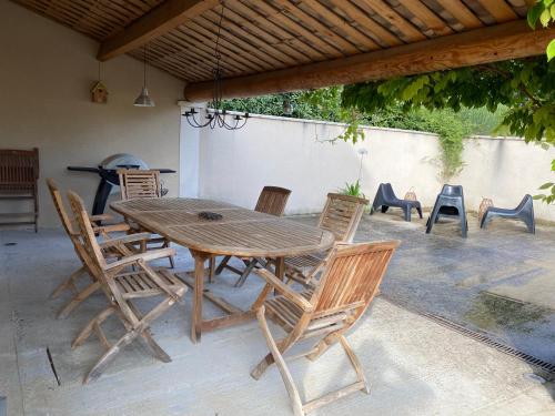 une table et des chaises en bois sur une terrasse dans l'établissement La Maison de Léonie 26, à Saint-Pantaléon-les-Vignes