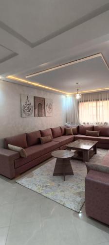 a living room with a brown couch and tables at La Maison Attawba in Beni Mellal
