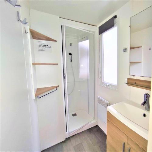 une salle de bain avec douche et lavabo dans l'établissement Mobil home 2 chambres Saint-Jean-de-Monts, à Saint-Jean-de-Monts