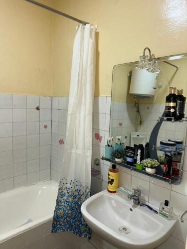 un bagno con un lavandino, una vasca e uno specchio di Chambre cosy au cœur de Rabat a Rabat