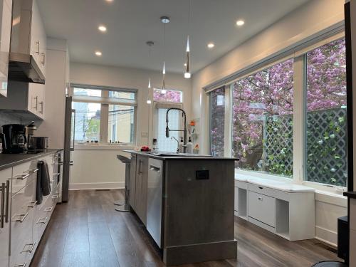 a kitchen with white cabinets and a large window at Upscale 3BR I Walk Score 99 I Metro I Free Parking in Washington, D.C.
