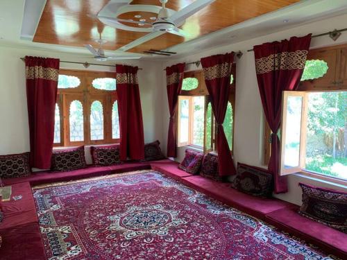 史卡杜的住宿－3-bedroom house near skardu airport with kitchen，一间红色窗帘和大地毯的房间