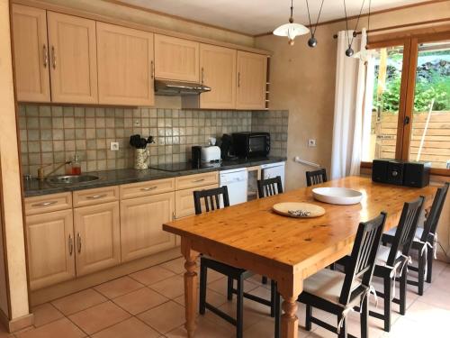 une cuisine avec une table et des chaises en bois dans l'établissement Gite de charme à Cadouin, à Cadouin