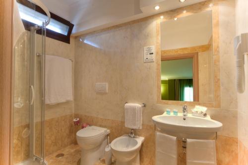 bagno con lavandino, servizi igienici e specchio di Dipendenza Hotel Galileo a Roma