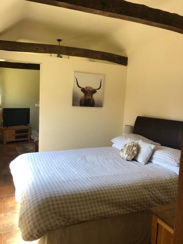 a bedroom with a bed with a bull head on the wall at Oak Barn in Wigginton