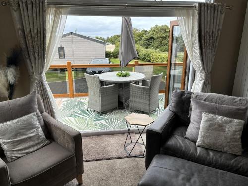 un soggiorno con un divano e un tavolo di Edinburgh Lodge-Sleeps 6-Pet Friendly-Beach&Views a Prestonpans