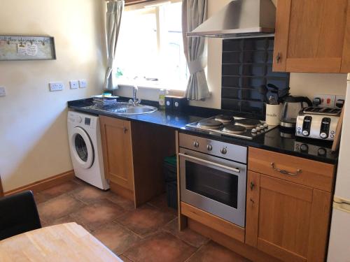 a kitchen with a sink and a stove top oven at Oak Barn in Wigginton