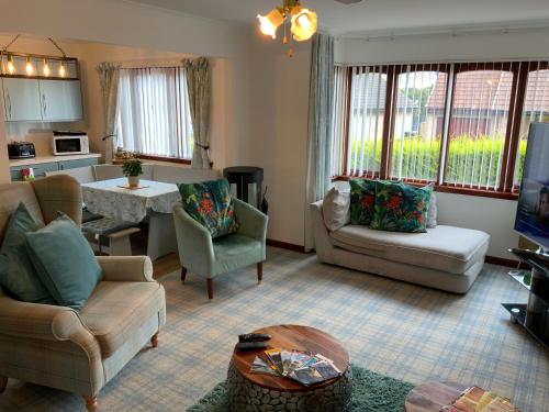 a living room with a couch and chairs and a table at Willow Lodge , Corskie Drive Macduff-Banff in Macduff