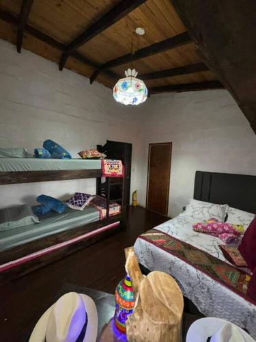 a bedroom with two bunk beds and a chandelier at Hospedaje San Martin - Finca completa - 18 personas in Pavas