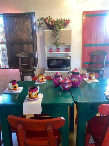 a kitchen with a table with tea pots on it at Hospedaje San Martin - Finca completa - 18 personas in Pavas