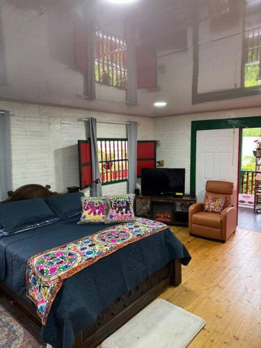a bedroom with a bed and a couch and a chair at Hospedaje San Martin - Finca completa - 18 personas in Pavas