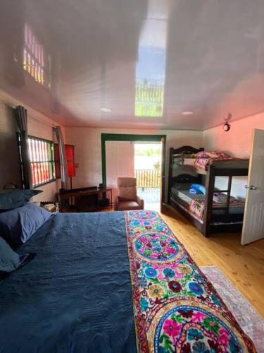 a bedroom with a large bed with a blue blanket at Hospedaje San Martin - Finca completa - 18 personas in Pavas