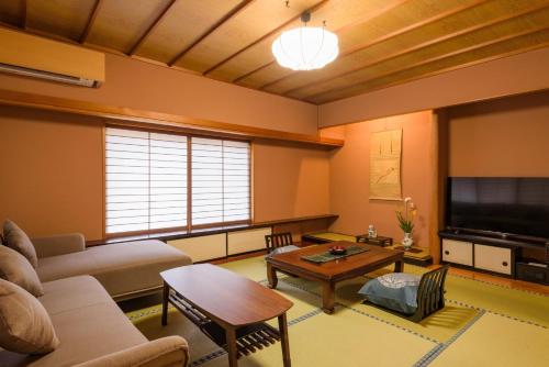 a living room with a couch and a table at Shirasagiyu Tawaraya in Kaga