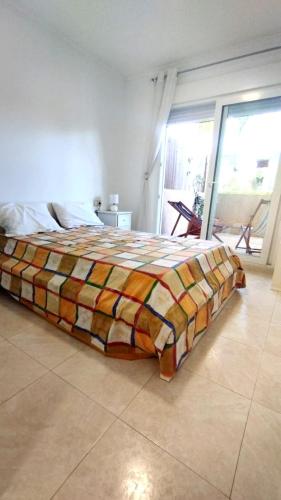 a bedroom with a bed with a colorful blanket at Apartamento Familiar Jávea en Planta Baja in Jávea