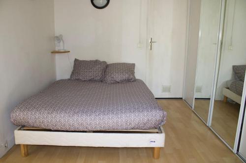 Bett in einem Zimmer mit Spiegel in der Unterkunft Charmant Vintage Chaville in Chaville