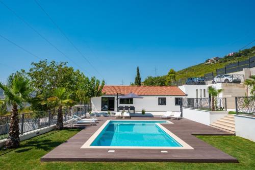 a villa with a swimming pool and a house at Villa Florinda with Pool and Prime Location near Split in Srinjine