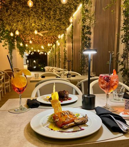 a table with two plates of food and glasses of wine at Holiday Inn Rosario by IHG in Rosario