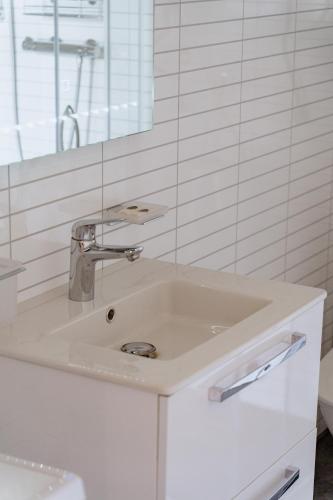 a white bathroom with a sink and a mirror at Forrest Guest House Ameli in Ķesterciems