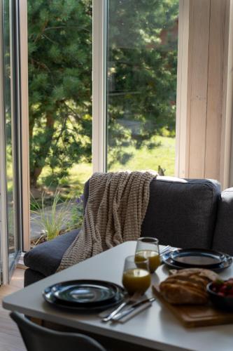 a table with a plate of food and glasses of wine at Forrest Guest House Ameli in Ķesterciems