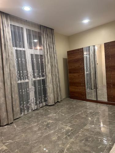 a living room with a large window and marble floor at AL- aqyr Rest Garden أستراحة حارة العقر in Nizwa