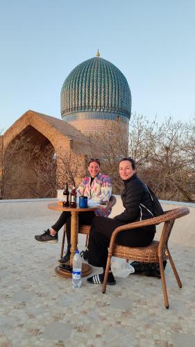 two people sitting at a table in front of a building at HOTEL MEHRIBON in Samarkand