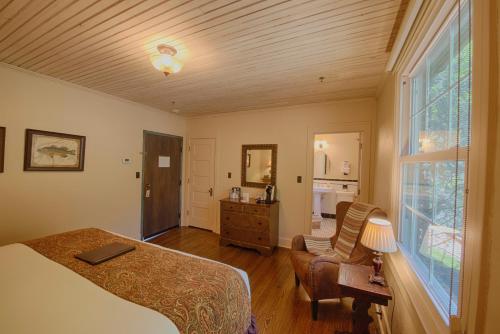 a bedroom with a bed and a chair and a window at Historic Tapoco Lodge Resort in Tapoco