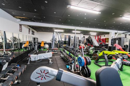 a gym filled with lots of machines and equipment at Suite D&S Luxury Room in Firminy