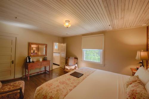 a bedroom with a bed and a table and a window at Historic Tapoco Lodge Resort in Tapoco
