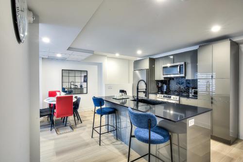 a kitchen with a counter and chairs in a room at Montreal Restful Nights, Adventure Days await! in Montréal