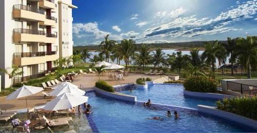 a swimming pool in a resort with people in it at Marina Flat & Náutica in Caldas Novas