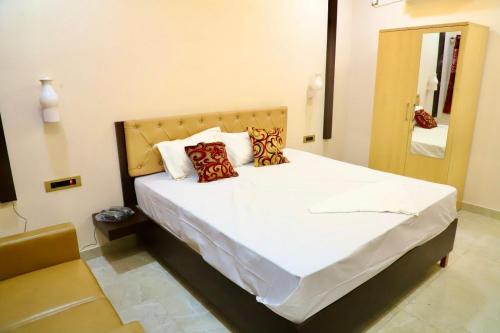 a bedroom with a bed with white sheets and pillows at Gokulam Grand in Srikalahasti