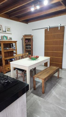 a white table and a bench in a room at Apto Duplex com Mezanino in Juquei