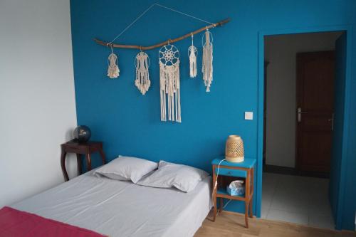 - une chambre bleue avec un lit et un mur bleu dans l'établissement L'océane, à Châtelaillon-Plage