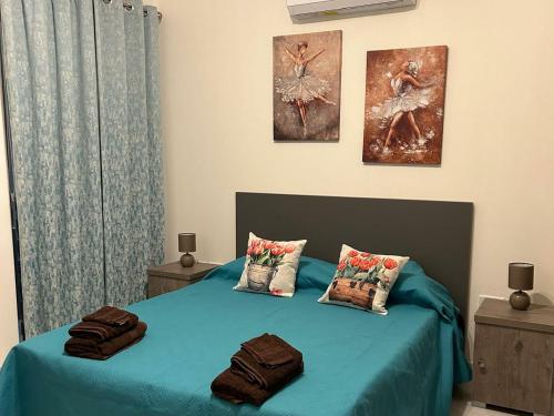 a bedroom with a blue bed with two pillows at Bella Qawra Maisonette in St. Paul's Bay