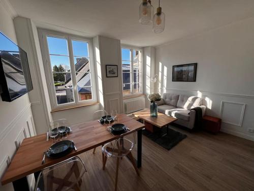 a living room with a table and a couch at Maison pour 10 personnes max en plein centre de Ste Mère Eglise in Sainte-Mère-Église